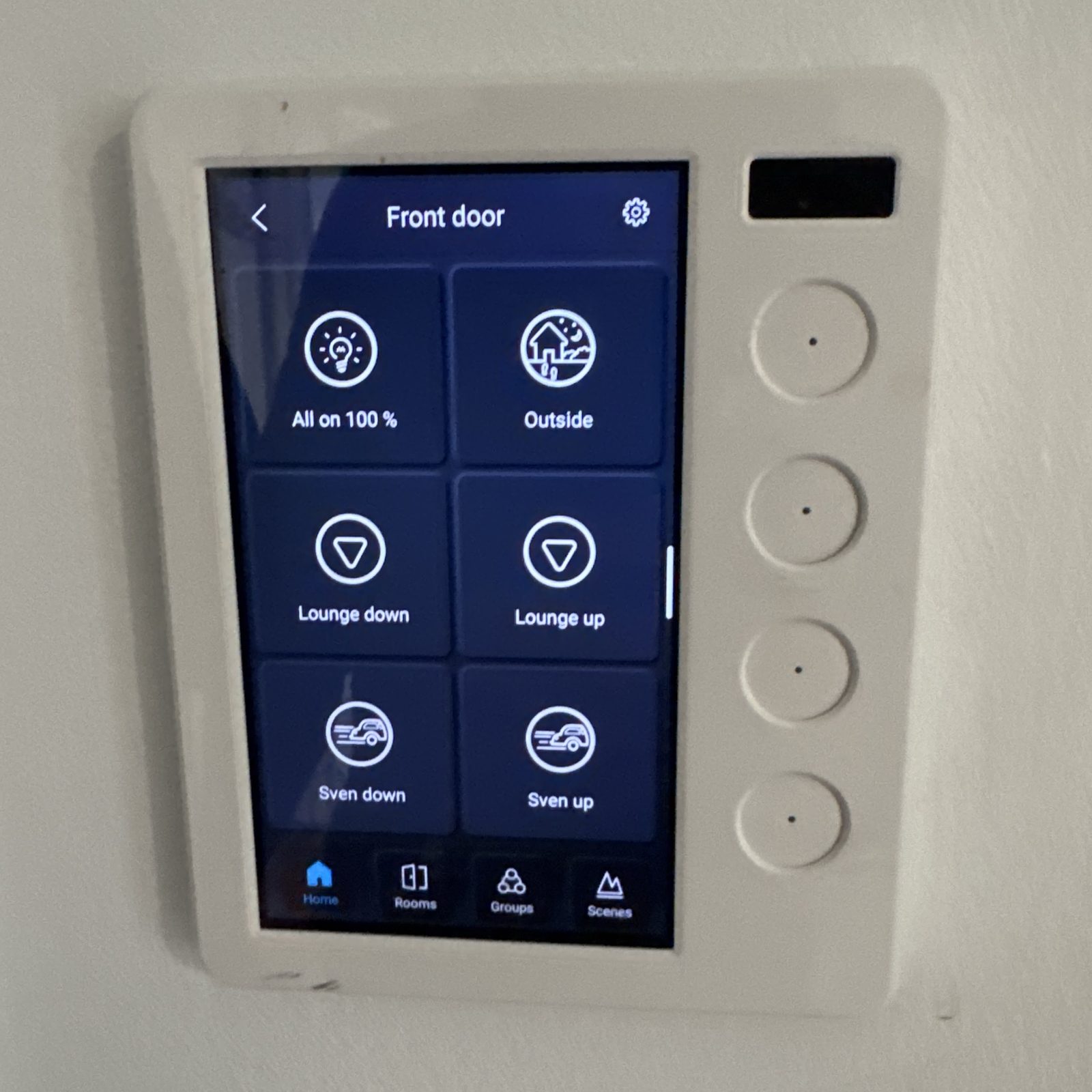 PIXIE wall touch panel labelled Front door with scene buttons for all on, outside lights, lounge blinds and garage doors